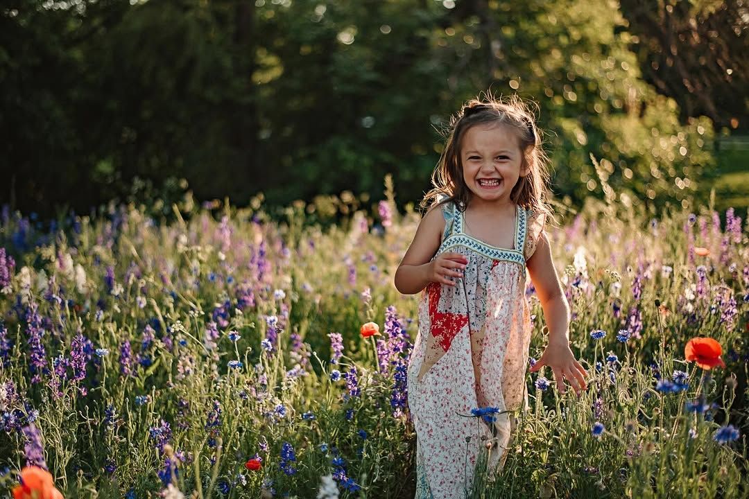 Little girl smiling in a field of wildflowers