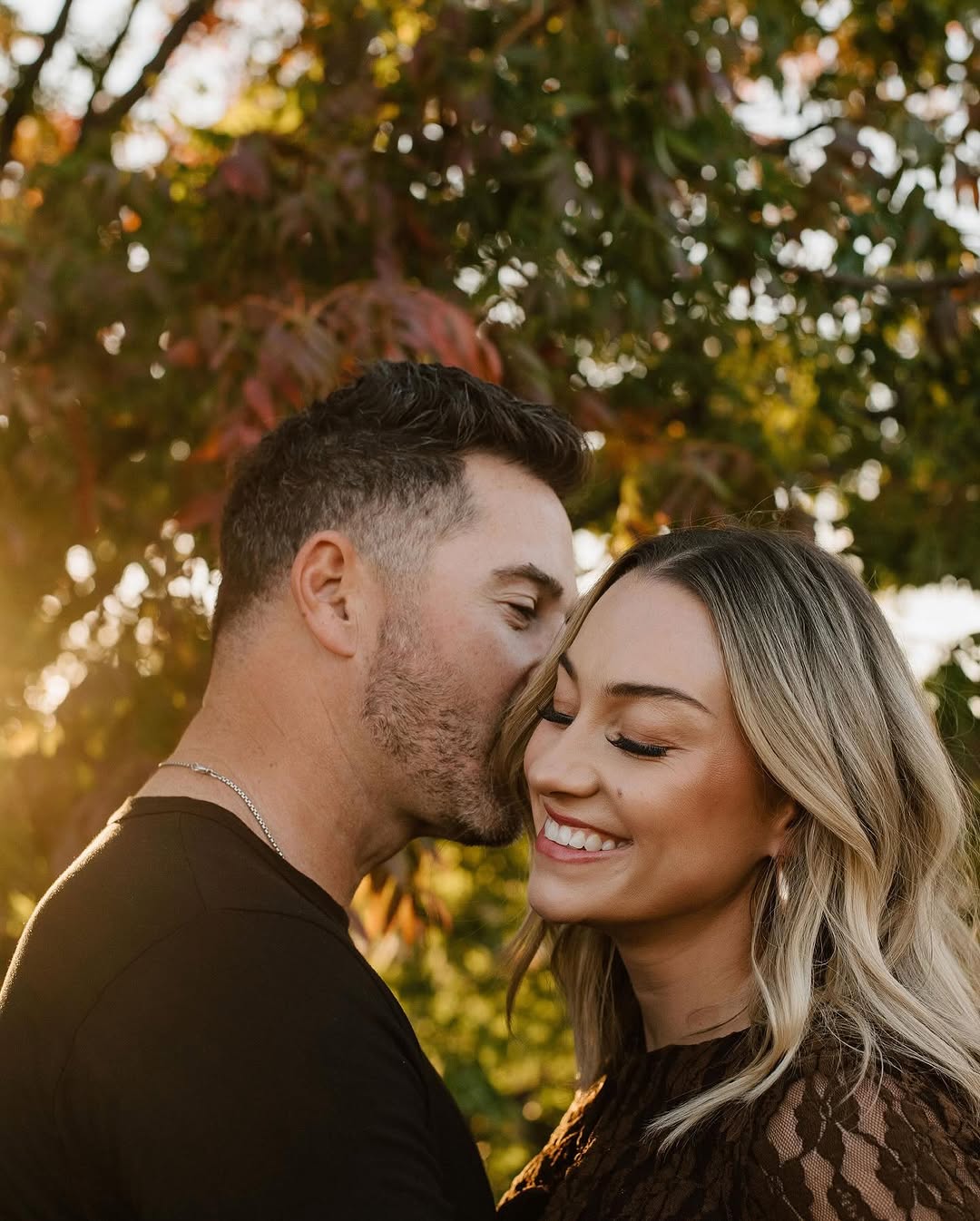 Couple laughing close together at golden hour