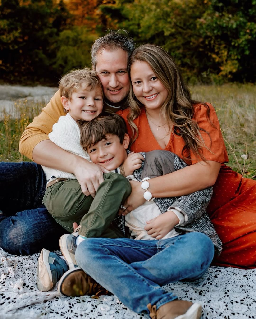 Family of four piled together on a blanket