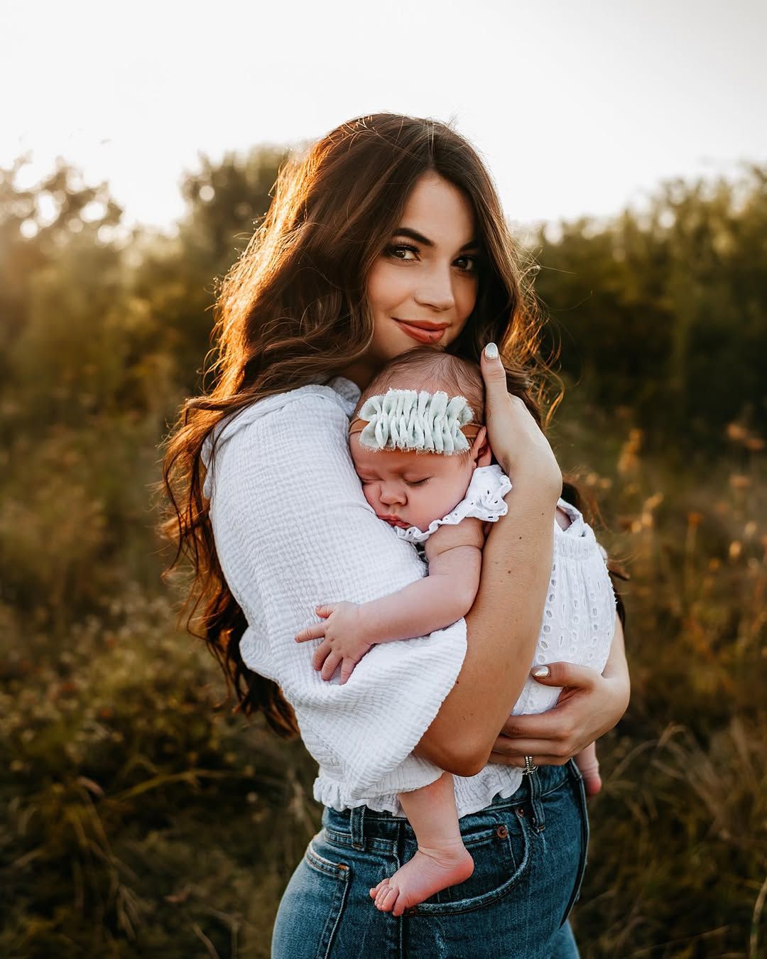 Mom holding her newborn at golden hour